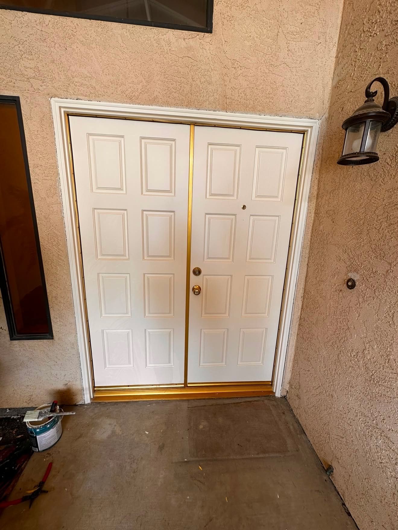 Refinished white entry door with brass hardware after repair by Handyman J