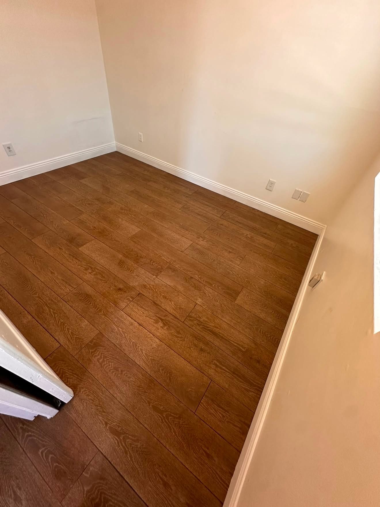Same room after new wood-look flooring installation, finished and clean